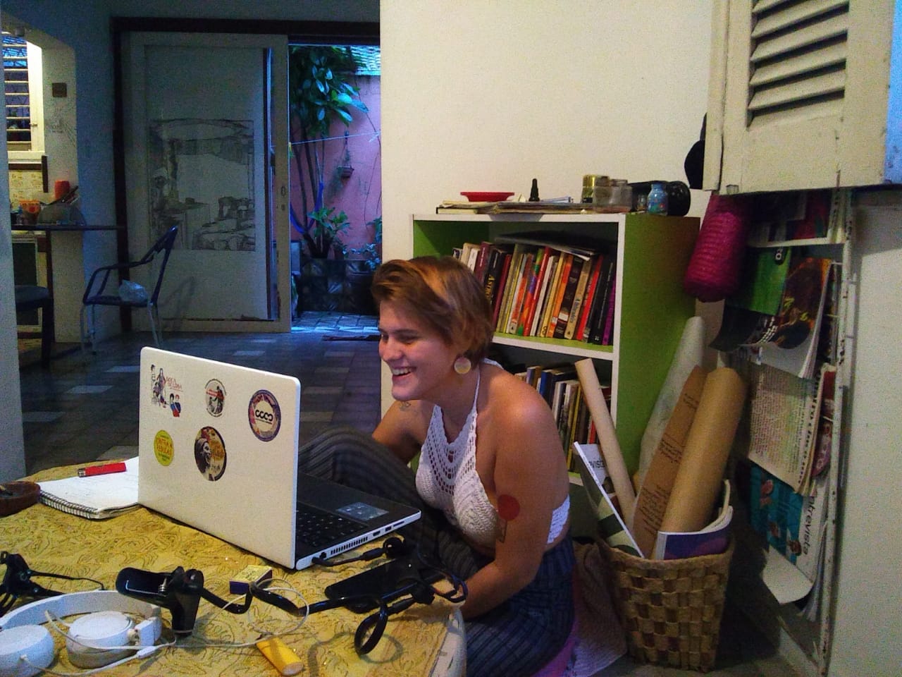mulher em uma casa sentada à frente de mesa olhando para computador